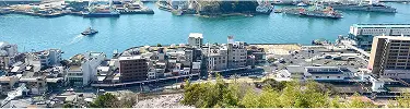 背景画像:尾道を上から見下ろした風景。海や街並みが写っています。