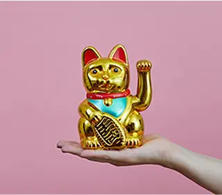 写真：手の上に金色の招き猫が乗っています